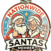 Circular nationwide Santa badge showing Santa and Mrs. Claus in red outfits, giving a thumbs-up, with a gift; reads 'NATIONWIDE SANTAS' and 'MEMBER 2026' at the bottom.